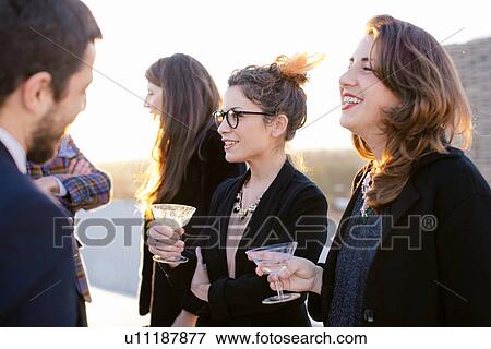 Group of friends laughing and drinking at party View Large Photo Image Stock Photo - Group of friends laughing and drinking at party. Fotosearch