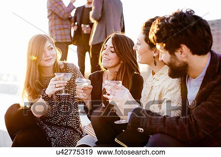Group of friends laughing and drinking at party View Large Photo Image Stock Photo - Group of friends laughing and drinking at party. Fotosearch