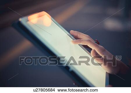 Hand of woman using digital tablet touchscreen at dusk View Large Photo Image Picture - Hand of woman using digital tablet touchscreen at dusk. Fotosearch