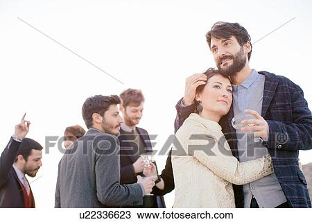 Heterosexual couple embracing at party View Large Photo Image Stock Image - Heterosexual couple embracing at party. Fotosearch