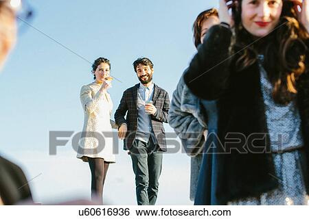 Heterosexual couple holding hands at party View Large Photo Image Stock Photograph - Heterosexual couple holding hands at party. Fotosearch