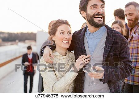 Heterosexual couple laughing together at party View Large Photo Image Stock Photography - Heterosexual couple laughing together at party. Fotosearch