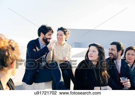Heterosexual couple making a toast at party View Large Photo Image Stock Image - Heterosexual couple making a toast at party. Fotosearch