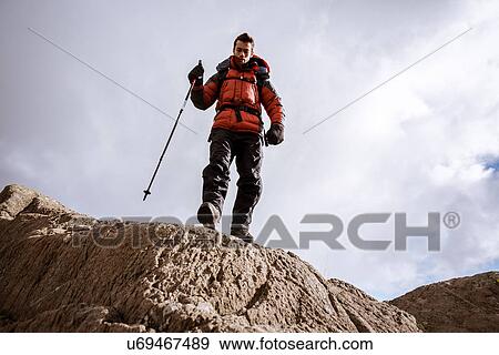 "Low angle view of young male hiker on rocks, The Lake District, Cumbria, UK" View Large Photo Image Stock Photo - "Low angle view of young male hiker on rocks, The Lake District, Cumbria, UK". Fotosearch