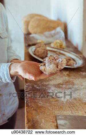 Stock Image - Male hands holding Tuscan wine bread with walnuts and raisins. Fotosearch