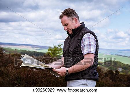 "Male hiker reading map on heather moors, Pateley Bridge, Nidderdale, Yorkshire Dales" View Large Photo Image Stock Photo - "Male hiker reading map on heather moors, Pateley Bridge, Nidderdale, Yorkshire Dales". Fotosearch