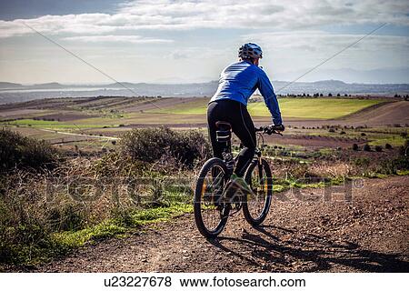 "Male mountain biker cycling down dirt track, Cagliari, Sardinia, Italy" View Large Photo Image Stock Photo - "Male mountain biker cycling down dirt track, Cagliari, Sardinia, Italy". Fotosearch