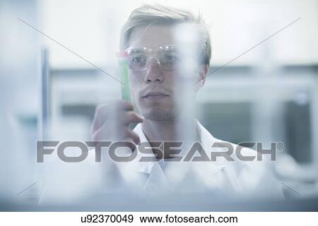Male scientist scrutinizing test tube in lab View Large Photo Image Stock Photo - Male scientist scrutinizing test tube in lab. Fotosearch