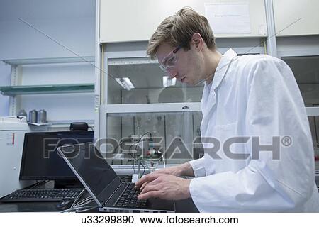 Male scientist typing on laptop in lab View Large Photo Image Stock Image - Male scientist typing on laptop in lab. Fotosearch