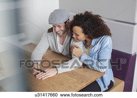 Man and woman looking at smartphone View Large Photo Image Stock Image - Man and woman looking at smartphone. Fotosearch