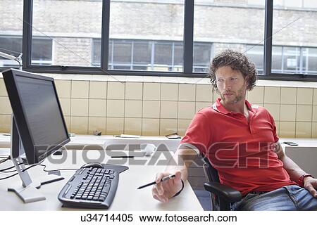 Man gazing at office desk View Large Photo Image Stock Photography - Man gazing at office desk. Fotosearch