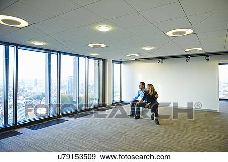 "Mature business couple looking from empty office window at Brussels cityscape, Belgium" View Large Photo Image Stock Photo - "Mature business couple looking from empty office window at Brussels cityscape, Belgium". Fotosearch