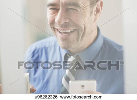 Mature businessman laughing in office View Large Photo Image Stock Photograph - Mature businessman laughing in office. Fotosearch