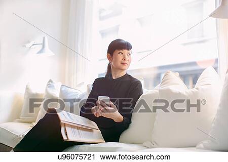 Mature businesswoman waiting on sofa in hotel lobby View Large Photo Image Stock Image - Mature businesswoman waiting on sofa in hotel lobby. Fotosearch