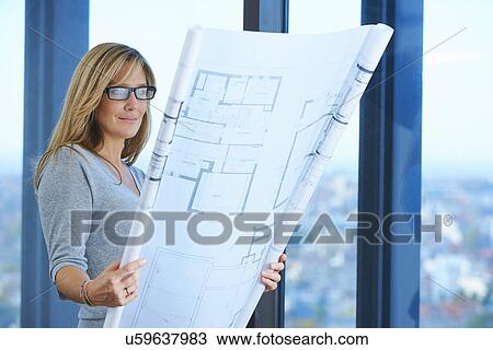 "Mature female architect looking at plans in skyscraper office, Brussels, Belgium" View Large Photo Image Stock Image - "Mature female architect looking at plans in skyscraper office, Brussels, Belgium". Fotosearch