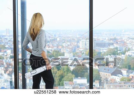 "Mature female architect looking from office window at Brussels cityscape, Belgium" View Large Photo Image Stock Photo - "Mature female architect looking from office window at Brussels cityscape, Belgium". Fotosearch