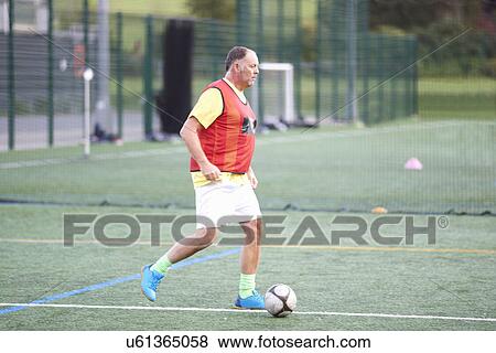 Mature man dribbling football View Large Photo Image Stock Photo - Mature man dribbling football. Fotosearch