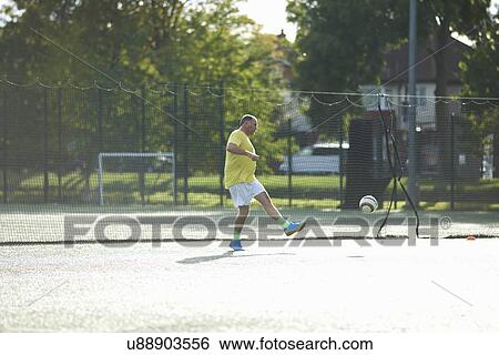 Mature man kicking football View Large Photo Image Stock Photograph - Mature man kicking football. Fotosearch