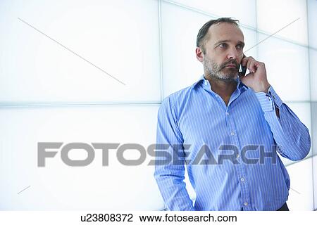 Mature man using smartphone against backlit wall panels View Large Photo Image Stock Image - Mature man using smartphone against backlit wall panels. Fotosearch