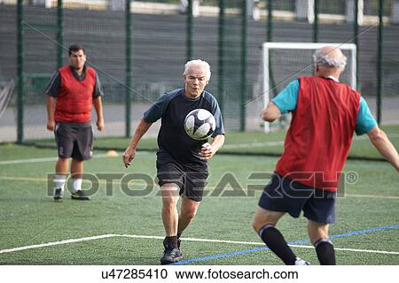 Stock Image - Men playing football. Fotosearch