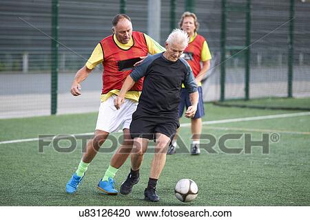 Stock Image - Men playing football. Fotosearch