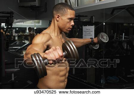 Stock Photography - "Mid adult man, lifting weights". Fotosearch