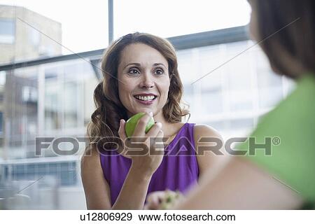 Mid adult woman eating apple View Large Photo Image Stock Photo - Mid adult woman eating apple. Fotosearch
