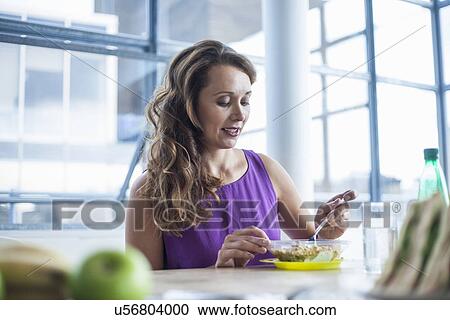 Mid adult woman eating lunch View Large Photo Image Stock Image - Mid adult woman eating lunch. Fotosearch