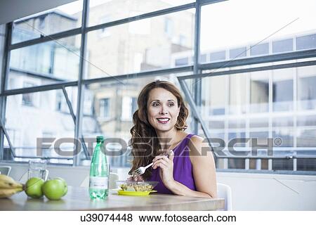 Mid adult woman eating lunch View Large Photo Image Stock Photo - Mid adult woman eating lunch. Fotosearch