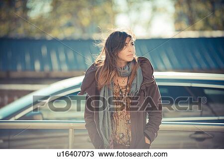 Mid adult woman standing on roadside gazing upward View Large Photo Image Stock Image - Mid adult woman standing on roadside gazing upward. Fotosearch