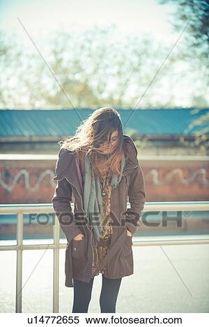 Mid adult woman standing on roadside looking down View Large Photo Image Stock Photography - Mid adult woman standing on roadside looking down. Fotosearch