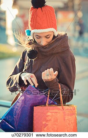 Mid adult woman wearing red pom pom hat searching shopping bags View Large Photo Image Stock Image - Mid adult woman wearing red pom pom hat searching shopping bags. Fotosearch