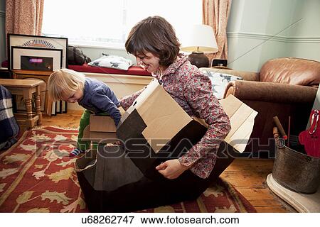 Mother and son playing with cardboard boxes in living room View Large Photo Image Stock Photo - Mother and son playing with cardboard boxes in living room. Fotosearch