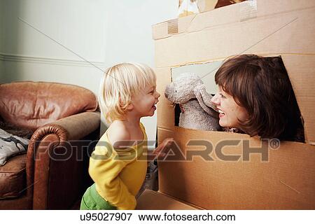 Mother and son playing with cardboard box window in living room View Large Photo Image Stock Photo - Mother and son playing with cardboard box window in living room. Fotosearch