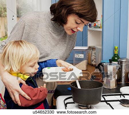 Mother and son pouring milk in porridge pan in kitchen View Large Photo Image Stock Image - Mother and son pouring milk in porridge pan in kitchen. Fotosearch