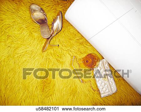 Stock Image - "Mules, handbag and wine glass on yellow furry rug". Fotosearch
