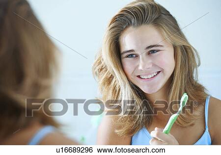 Over the shoulder view of teenage girl with tooth brush View Large Photo Image Stock Photograph - Over the shoulder view of teenage girl with tooth brush. Fotosearch