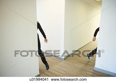 Stock Image - People walking across corridor. Fotosearch