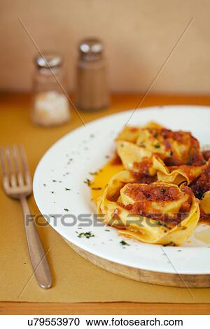 Stock Image - Plate of fresh ravioli pasta with tomato and meat sauce. Fotosearch
