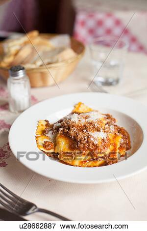 Stock Photo - "Plate of ravioli with potato filling and sauce of wild boar and tomato, Tuscany, Italy". Fotosearch