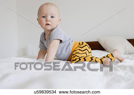 Portrait of baby girl crawling on bed View Large Photo Image Picture - Portrait of baby girl crawling on bed. Fotosearch