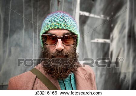 Stock Photograph - Portrait of bearded mature man with beanie and sunglasses. Fotosearch