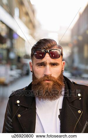 Stock Image - Portrait of bearded young man with sunglasses. Fotosearch