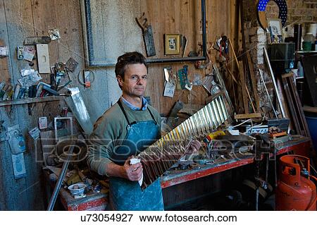 Stock Photo - Portrait of glass engraver holding polished glass material in workshop. Fotosearch