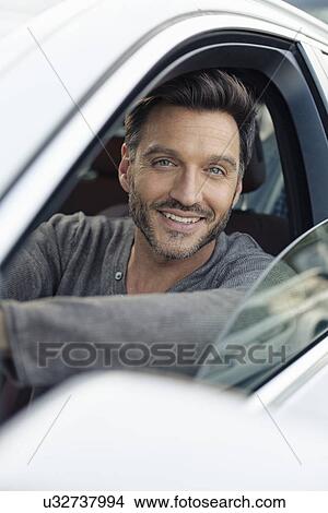 Picture - Portrait of handsome mature man leaning on car window. Fotosearch
