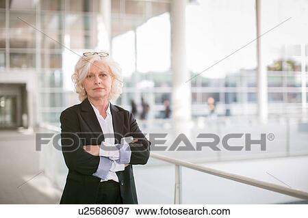 Portrait of mature businesswoman standing on walkway View Large Photo Image Stock Photo - Portrait of mature businesswoman standing on walkway. Fotosearch