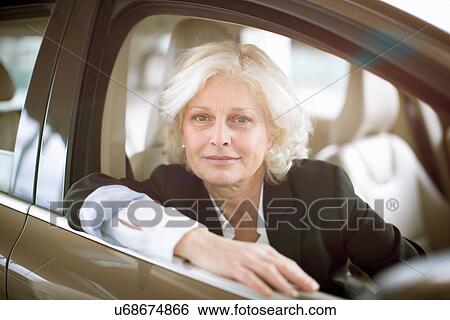 Portrait of mature businesswoman sitting in driving seat of car View Large Photo Image Stock Photograph - Portrait of mature businesswoman sitting in driving seat of car. Fotosearch