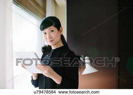 Picture - Portrait of mature businesswoman using digital tablet in office. Fotosearch