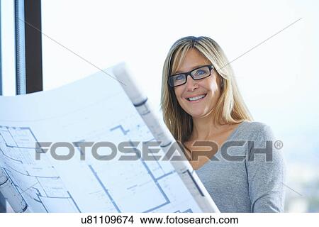 Portrait of mature female architect with plans in office View Large Photo Image Picture - Portrait of mature female architect with plans in office. Fotosearch