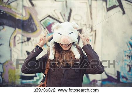 Portrait of mid adult woman hiding face with pig fur hat View Large Photo Image Stock Image - Portrait of mid adult woman hiding face with pig fur hat. Fotosearch